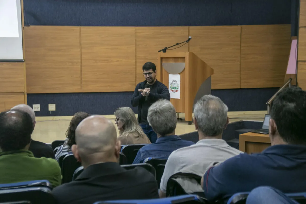 Palestrante fala aos servidores em frente à tribuna do auditório